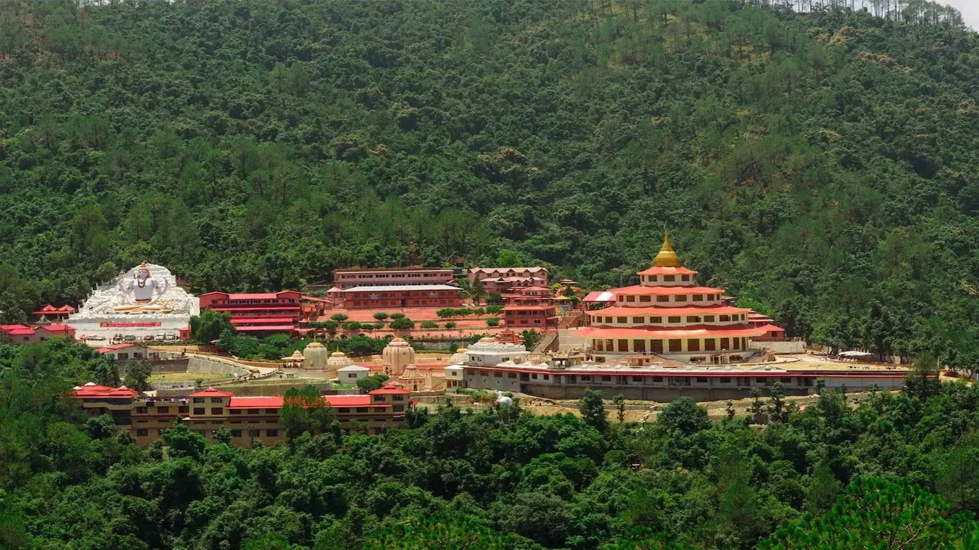 The Shri Kalyanika Dol Ashram complex set among forested Kumaon hills
