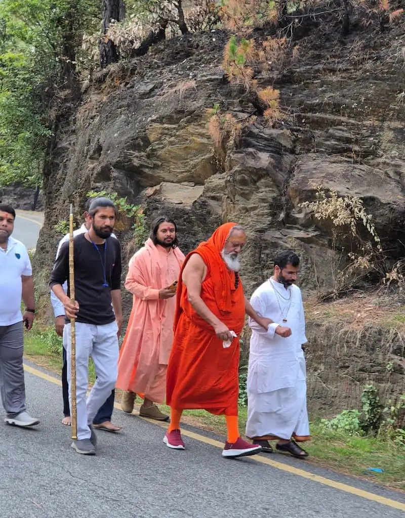 Senior swamis of the Udasin lineage walking a hill road near Dol Ashram